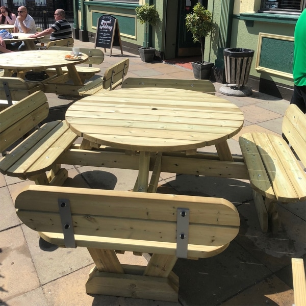 Traditional round pub style picnic benches with seat backs in outdoor restaurant seating area