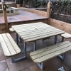 Modern 12 seater wooden picnic table with steel step-through frame and umbrella hole in hospitality venue outdoor seating area