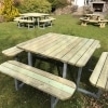 Multiple large 12 seater wooden picnic tables with rounded edges and steel frame in outdoor hospitality venue