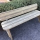 Traditional long wooden park bench with rounded edges in outdoor venue