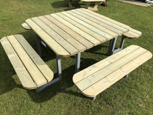 12 seater square wooden picnic bench with steel frame and rounded edges in outdoor venue